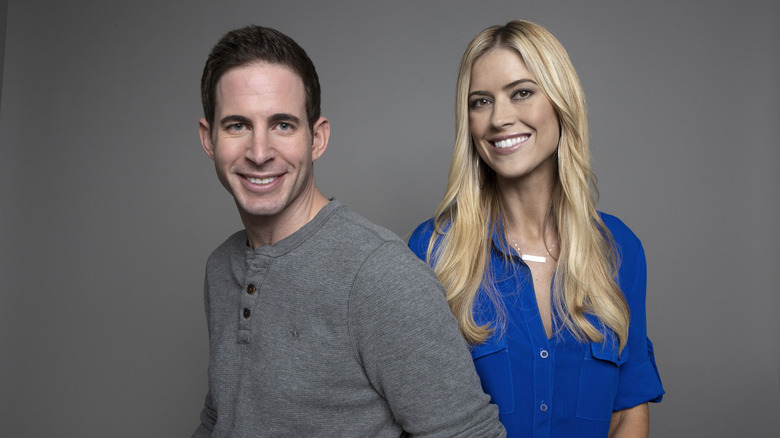 Tarek El Moussa and Christina Hall posing against a grey backdrop