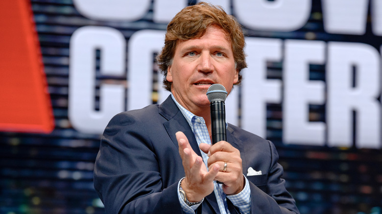 Tucker Carlson talking into a microphone