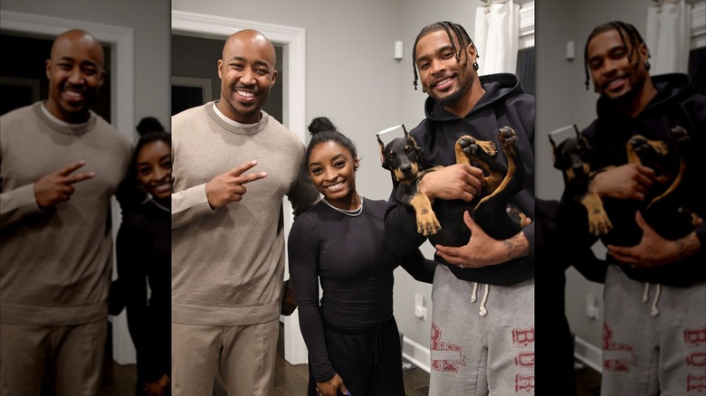 Simone Biles and husband take a photo with breeder and breeder's Doberman puppy