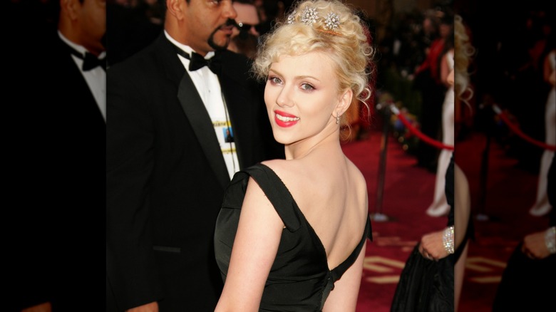 Scarlett Johansson smiling at the 2005 Academy Awards with a blonde updo and a diamond headpiece