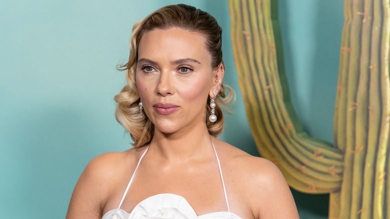 Scarlett Johansson posing in a white strappy dress