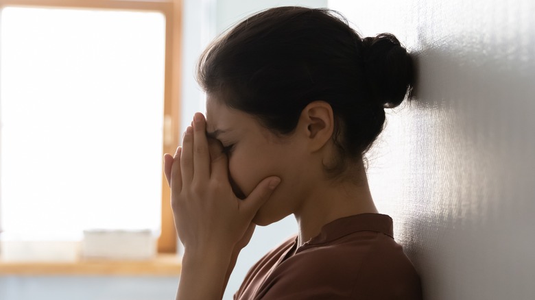 stressed woman with face in hands