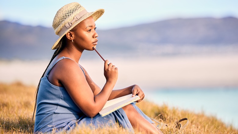 Woman writing in a journal outdoors