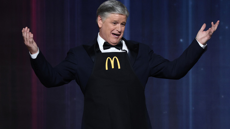 Sean Hannity striking a funny pose while wearing a McDonald's apron