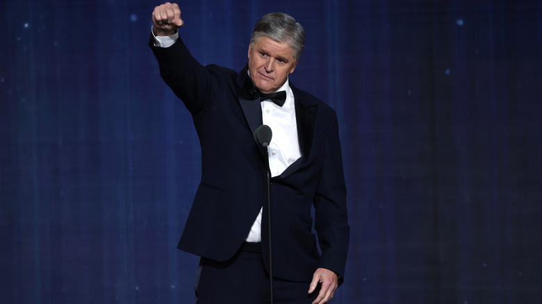 Sean Hannity attempting what appears to be an imaginary mic drop during a speech