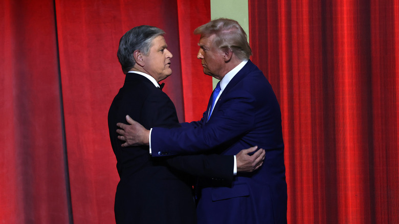 Sean Hannity hugs Donald Trump in front of red background