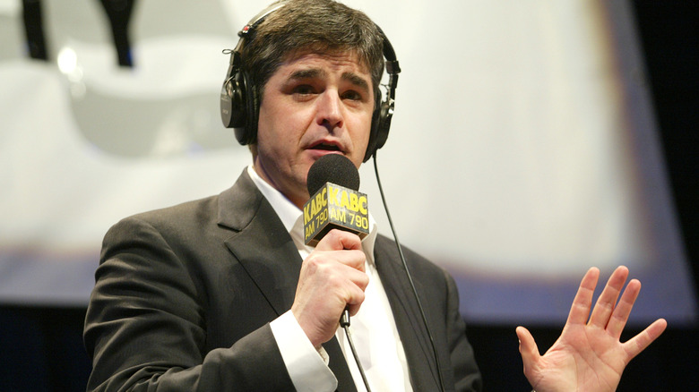 Sean Hannity wearing headphones, holding a microphone labeled "KABC AM 790"