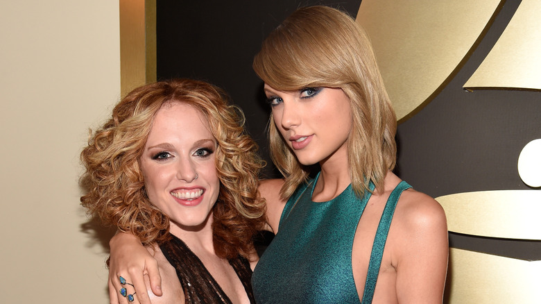 Abigail Anderson brown dress Taylor Swift blue dress in front of gold and black Grammys wall