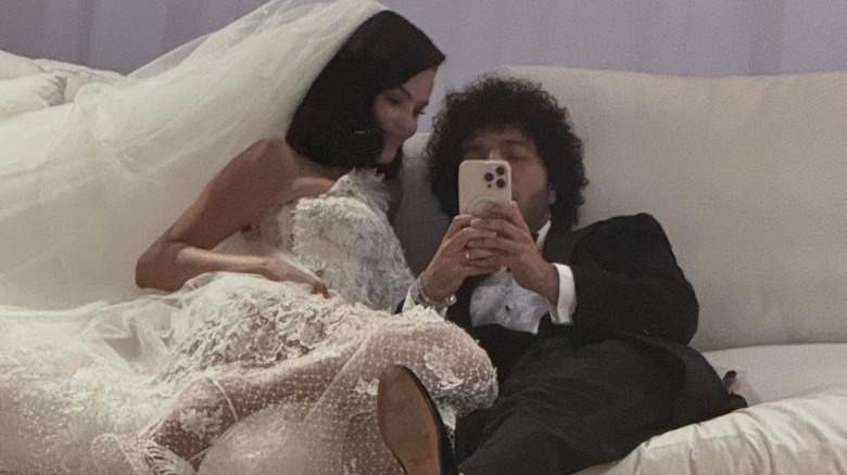 Selena Gomez smiling in her wedding dress as Benny Blanco takes a mirror selfie.