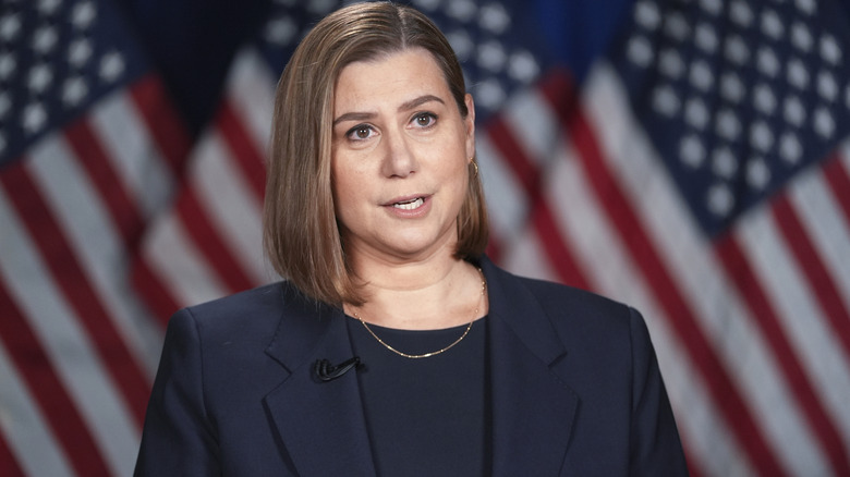 Elissa Slotkin speaking in front of an American flag in a black suit