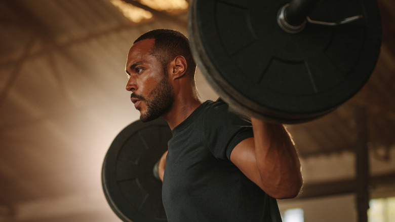 Man with heavy barbell on his back