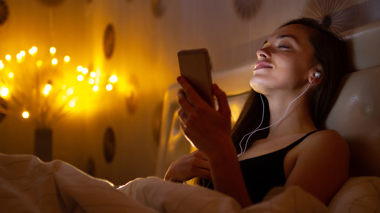 woman with headphone in bed