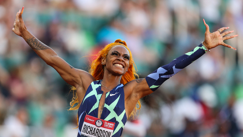 Sha'carri Richardson smiling with arms outstretched