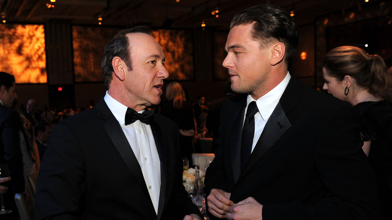 Leonardo DiCaprio speaking to Kevin Spacey while both wear tuxes