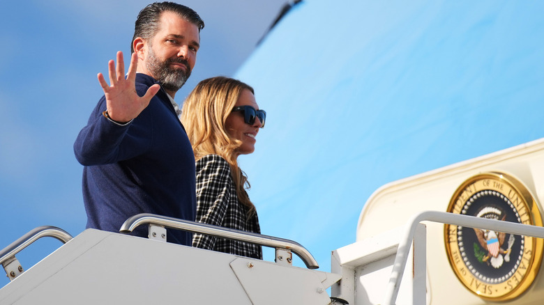 Donald Trump Jr. waving as he and Bettina Anderson board Air Force One