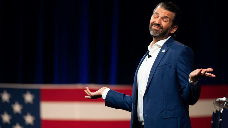 Donald Trump Jr. shrugging in a navy suit