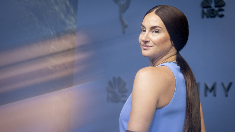 Shailene Woodley looking over her shoulder in a blue tank top
