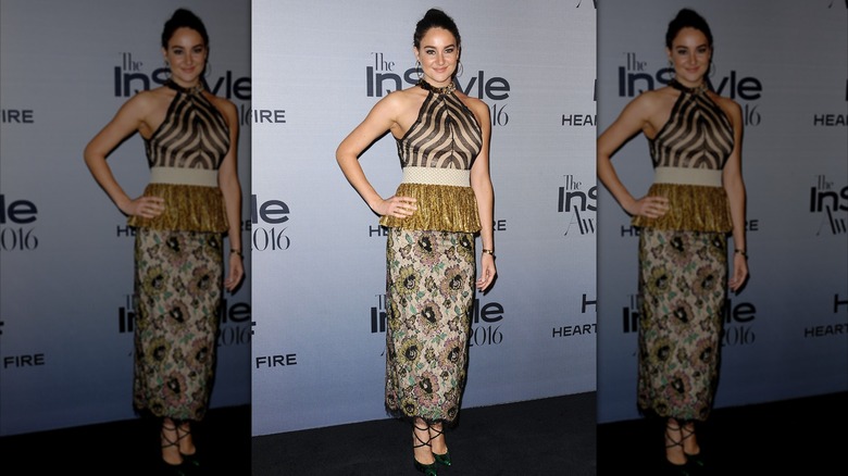 Shailene Woodley smiles with one hand on her hip