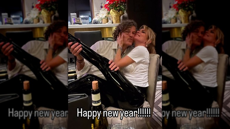 Frédéric Thiébaud holds Shania Twain's leg as he leans in close to her.