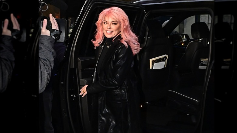 Shania Twain wears a black outfit and pink hair
