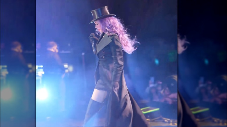 Shania Twain on stage with a black coat and top hat