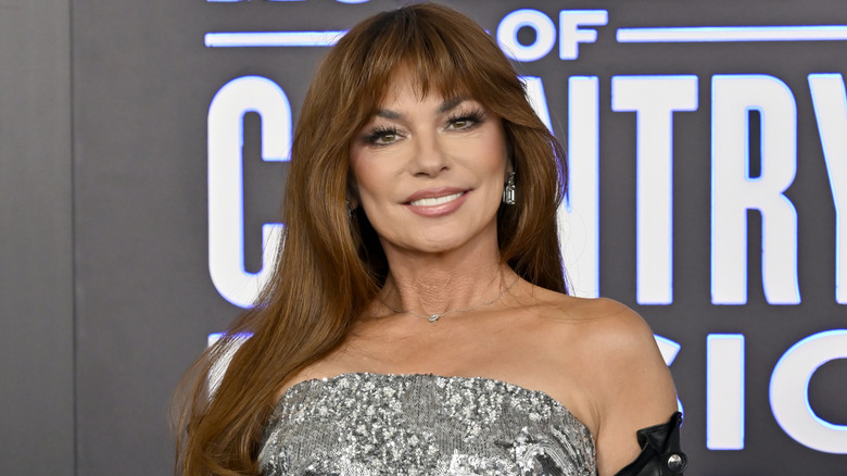 A smiling Shania Twain posing on the red carpet at the 2026 ACM Awards