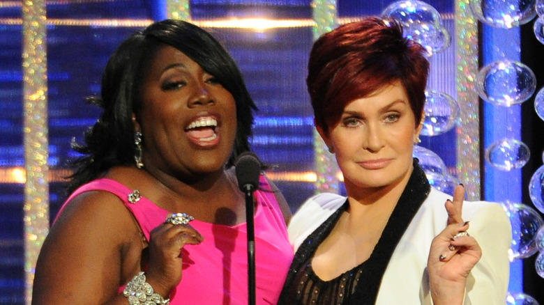 Sheryl Underwood with Sharon Osbourne at the podium of an award show