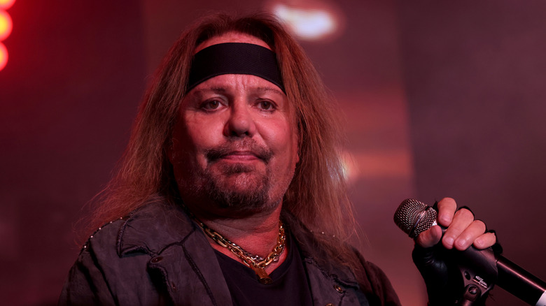 Vince Neil holding a microphone during concert