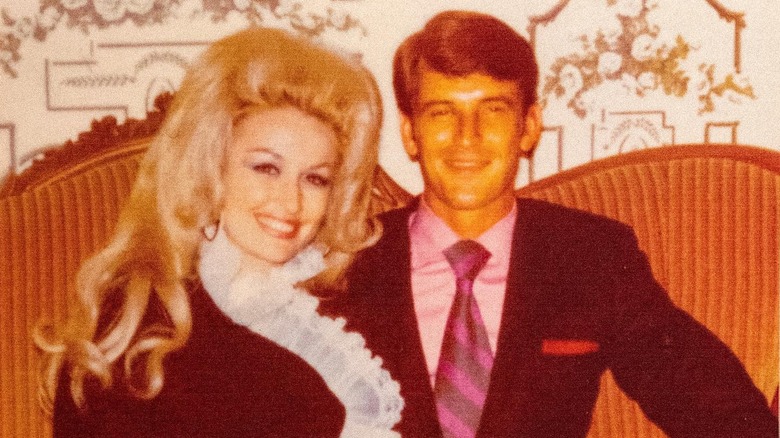 A photo of a young Dolly Parton and her husband, Carl Dean, sitting on a couch.