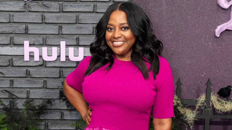 Sherri Shepherd posing in front of a brick background