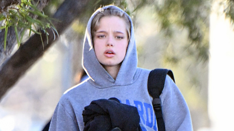 Shiloh Jolie-Pitt walking while holding a hoodie