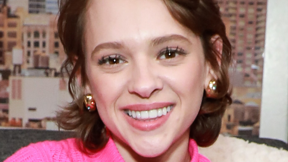 Shira Haas smiling with gold earrings
