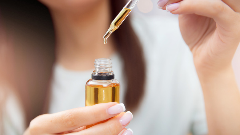 Woman holding bottle of castor oil