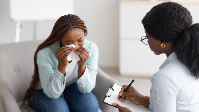 Woman crying while another takes notes