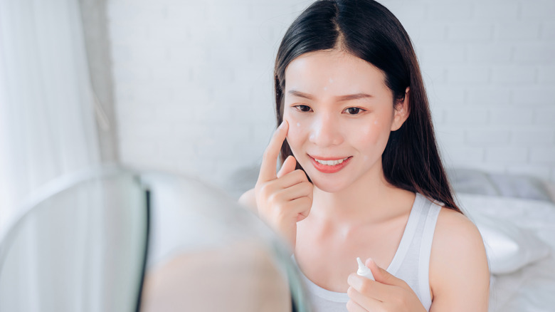 woman happy with her skin applying product