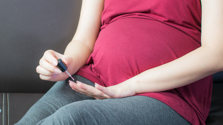 Pregnant woman painting nails