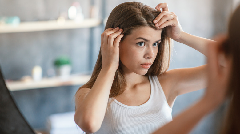 woman checking her scalp 