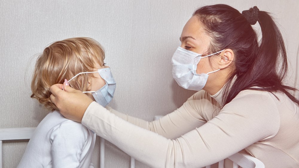 Mother putting mask on a child