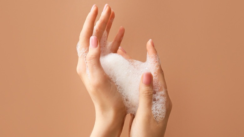 Hands lathering foamy soap