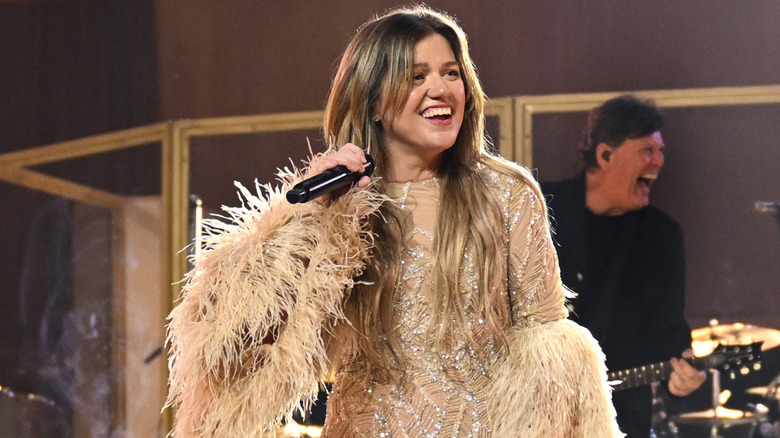 image of Kelly Clarkson on stage laughing at something she is seeing off-screen