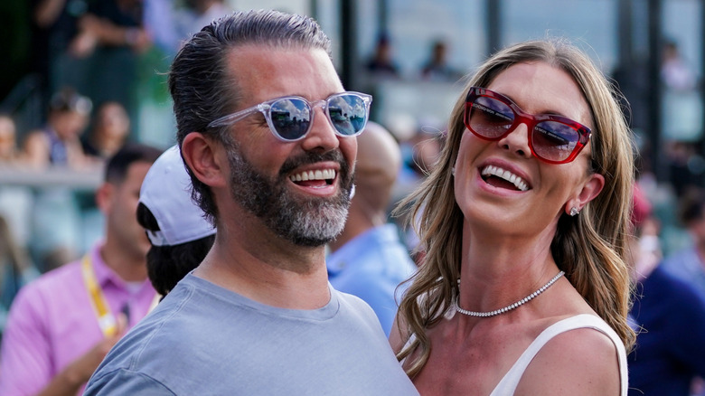 Bettina Anderson laughing with Donald Trump Jr. while both wearing sunglasses