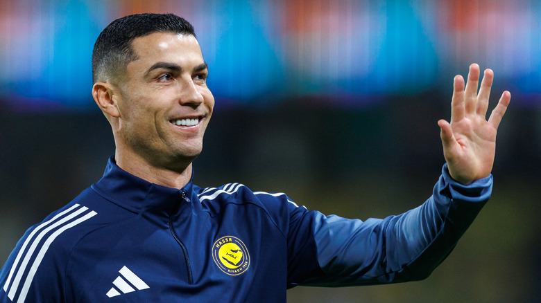 Side profile of Cristiano Ronaldo smiling and waving