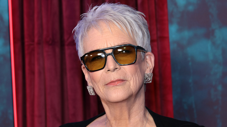 image of Jamie Lee Curtis smiling and wearing sunglasses on the red carpet of an event