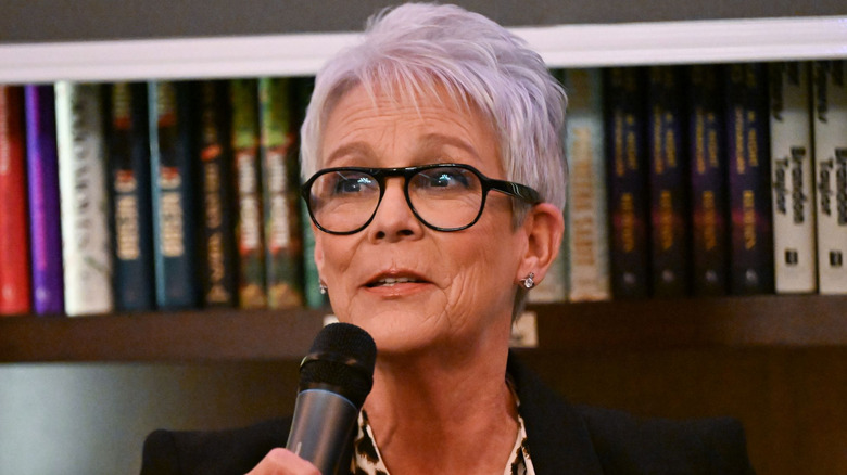Image of Jamie Lee Curtis speaking into a microphone at an event