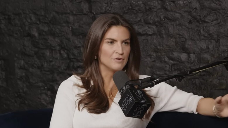Kaitlan Collins in front of a podcast microphone