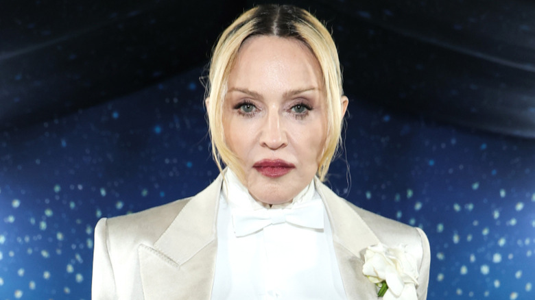 Madonna with blonde hair and black roots staring at the camera