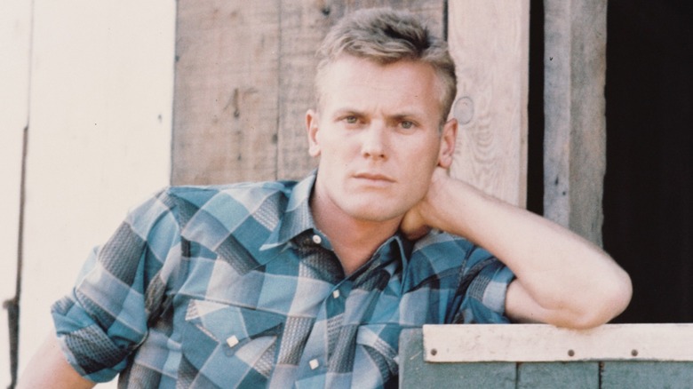 Tab Hunter leaning on a stable door