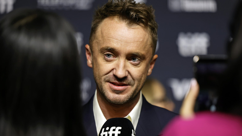 Tom Felton being interviewed at TIFF in a suit