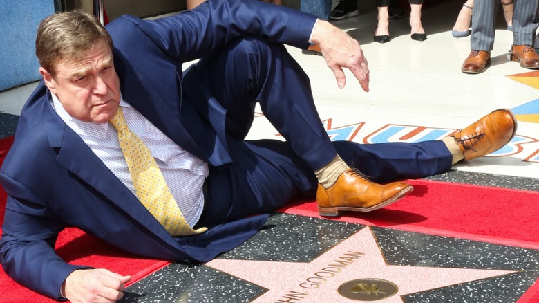John Goodman laying next to his Hollywood Walk of Fame star