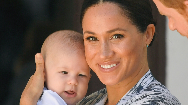 Meghan Markle holding Prince Archie while smiling